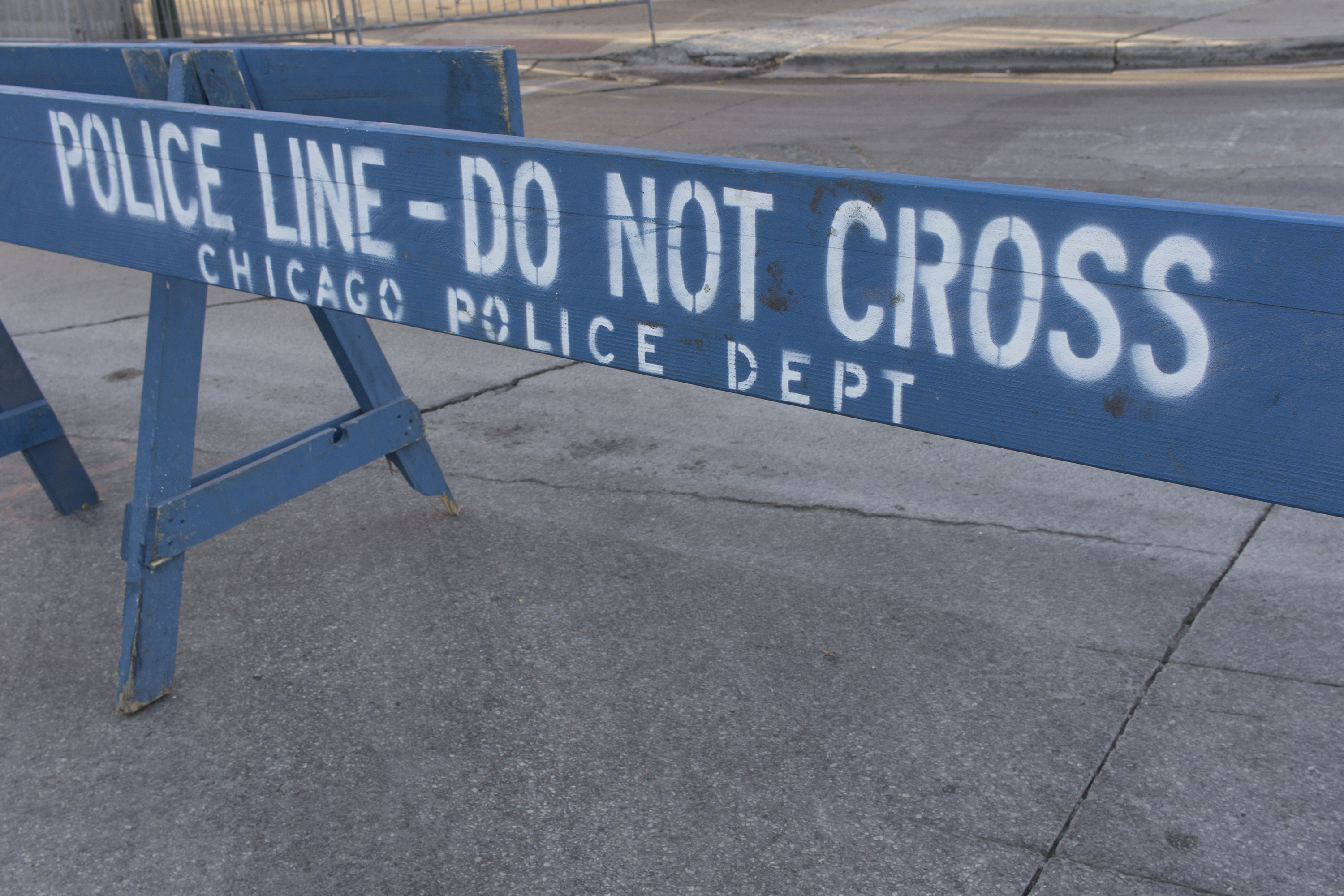 Blue wooden police barricade on city street.
